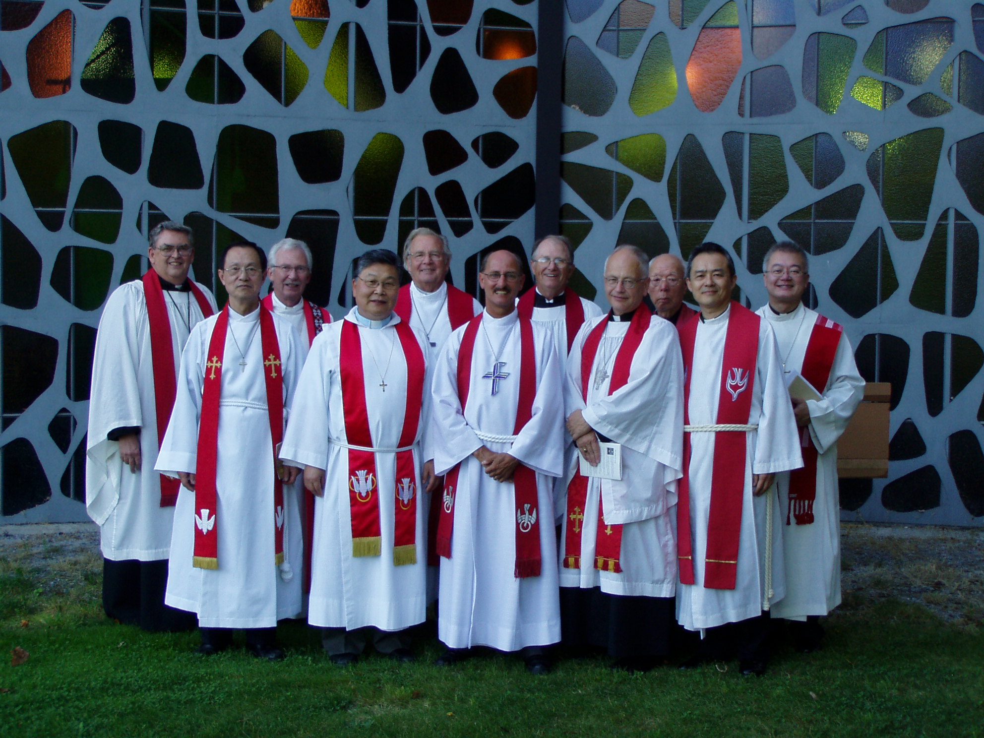 Rev. Dr. Steven Harold stands outside Trinity Lutheran Church in Richmond, BC, in front of a stained glass window during his installation service. He is flanked by participating pastors, including then-ABC District President Rev. Donald Schiemann.